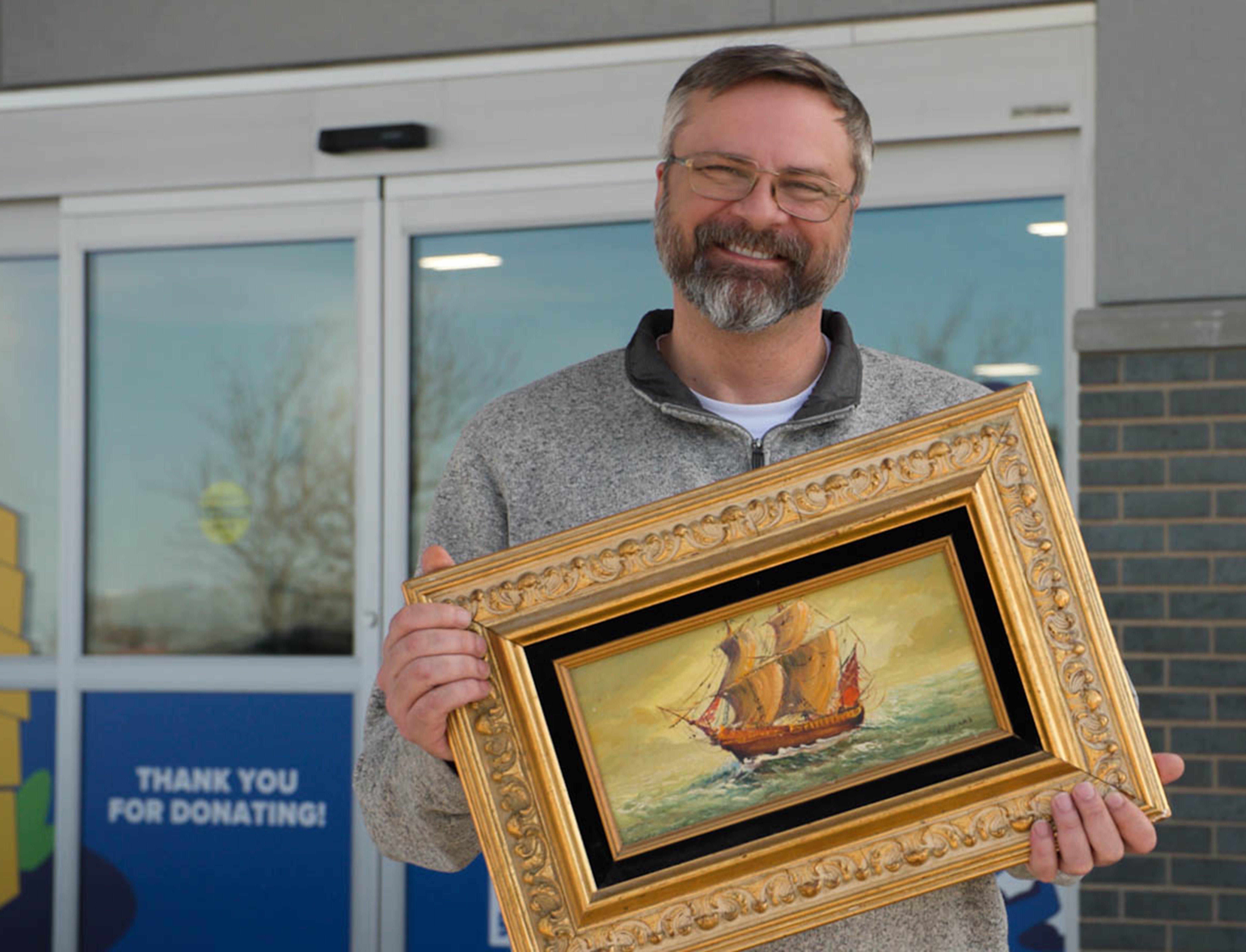 Photo of a man donating an old painting
